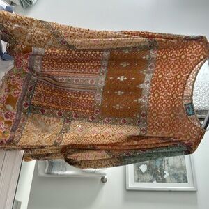 Johnny was blouse with flocking design.  Flowing hem  shades of peach and orange